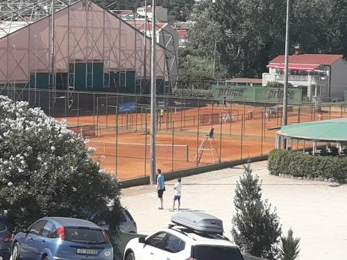 a man and a child standing on a tennis court at Rooms Ana in Split