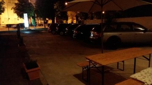 a table with an umbrella next to a row of parked cars at Guest House Vanja in Mostar