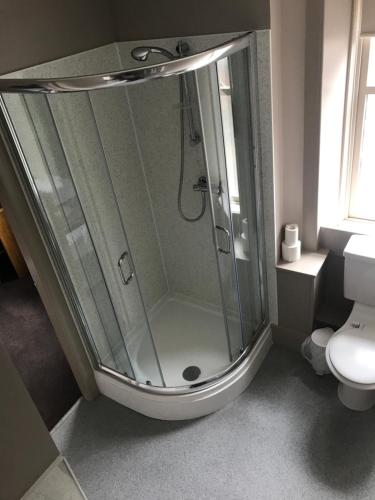 a glass shower in a bathroom with a toilet at Buchan Hotel in Ellon