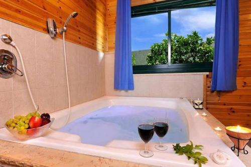 une baignoire avec deux verres de vin dans l'établissement Villa Joe, à Peqi‘in H̱adasha