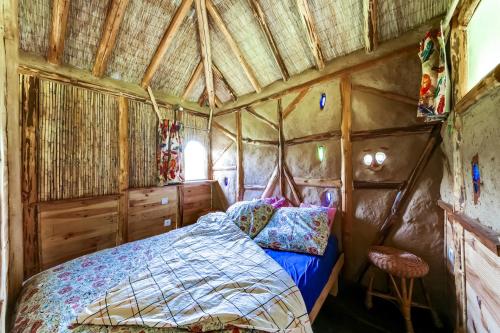 a bedroom in a tree house with a bed at La Clairière du Verbamont in Claudon