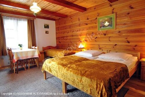 a bedroom with two beds and a table in a room at Dunia - Dom na wyłączność in Kazimierz Dolny