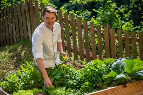 a man is standing in a garden at Rohrmooser Schlössl in Schladming