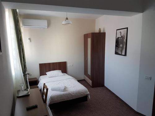 a bedroom with a bed and a desk and a mirror at SkyRoomsHorezu in Horezu