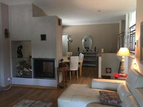 a living room with a couch and a fireplace at la grange in Jeuxey