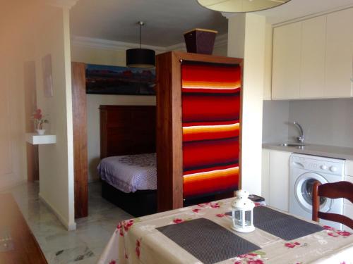 a room with a bed and a kitchen with a table at Apartamentos vista a tres continentes in La Línea de la Concepción