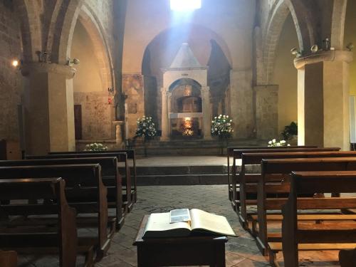 an empty church with chairs and a book on a table at Notti Etrusche a Sovana in Sovana