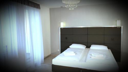 シュチェチンにあるGolden Palace Apartments EMILII PLATER 3 Szczecinのベッドルーム1室(ベッド1台、シャンデリア付)