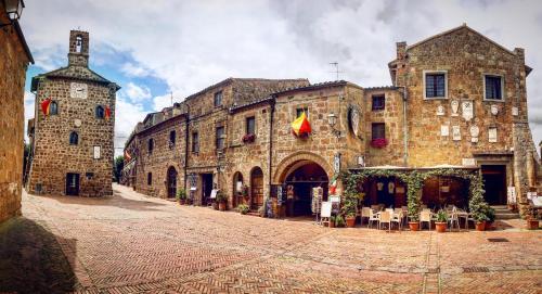 an old stone building with a street in front of it at Notti Etrusche a Sovana in Sovana