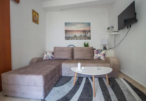 a living room with a brown couch and a table at Aneta Apartments in Risan