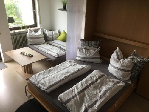 シェーンヴァルトにあるschwarzwald-apartmentのベッド2台、枕、テーブルが備わる客室です。
