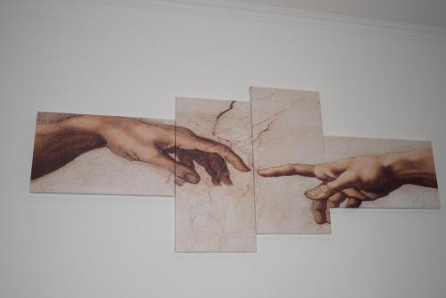 a painting of two hands on a wall at Anna e Franco Home in Rome