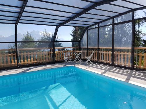 - une piscine avec une pergola et une piscine dans l'établissement Domaine de La Croix de Javernaz, à Villars-sur-Ollon