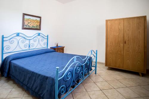レウカにあるPietra del Mediterraneoのベッドルーム1室(青いベッド1台、木製キャビネット付)