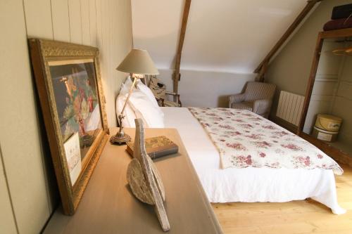 ein Schlafzimmer mit einem Bett und einem Tisch mit Spiegel in der Unterkunft La maison d'Alcime in Plumergat