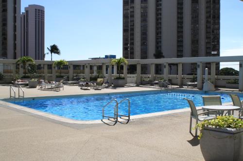 a swimming pool with chairs and a table in a building at LSI Resorts at Ala Moana in Honolulu