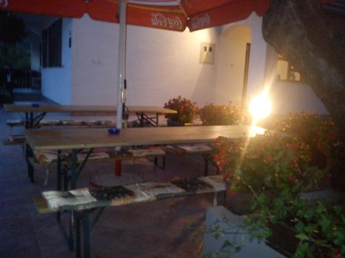 un gruppo di tavoli da picnic sotto un ombrellone di House Anamarija a Seliste Dreznicko