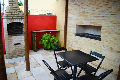 a table and chairs in a patio with a brick fireplace at Coco Verde Flats Natal in Natal