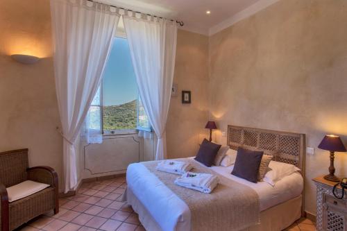 - une chambre avec un lit et une grande fenêtre dans l'établissement Mare E Monti - Hôtel de Charme, à Feliceto