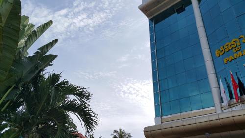 a tall building with flags on the side of it at PAMA Hotel in Kampong Chhnang