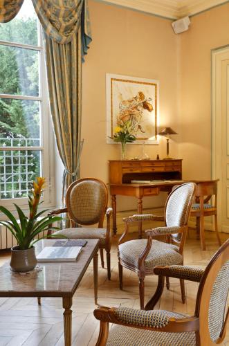 a living room with a piano and chairs and a table at Chateau de la Rozelle in Cellettes
