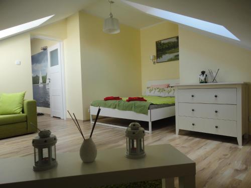 - une chambre avec un lit, une commode et une table dans l'établissement Apartament Relax, à Giżycko