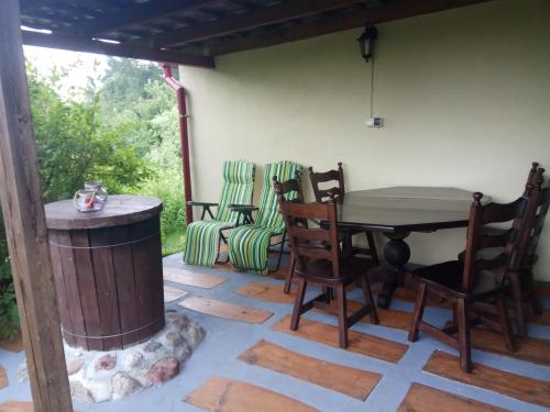 een patio met een tafel en stoelen en een open haard bij Domek pod brzozą in Mrągowo