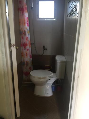 ein kleines Bad mit einem WC und einem Fenster in der Unterkunft SD4 Studio Apartment in Loculan