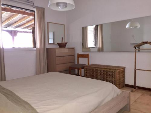 Schlafzimmer mit einem weißen Bett und einem Spiegel in der Unterkunft Sandy Beach Villas 17 in Pyla