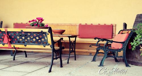 a table with two chairs and a table with flowers on it at AGRITURISMO CA'MATTEI in Pescantina