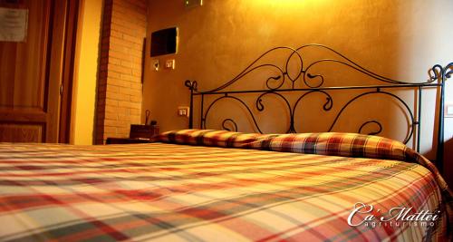 1 dormitorio con 1 cama con manta a cuadros en AGRITURISMO CA'MATTEI, en Pescantina