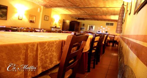 un comedor con una mesa larga y sillas en AGRITURISMO CA'MATTEI, en Pescantina