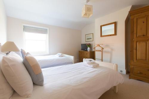 a bedroom with two white beds and a window at Drift In in Aldeburgh