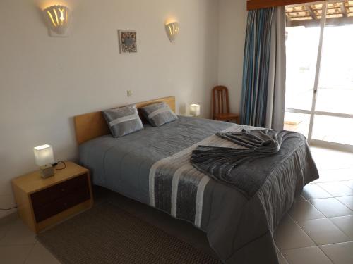 een slaapkamer met een bed met een deken erop bij Vila Gaivota Mare Azur in Ferragudo