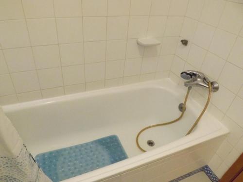 een wit bad met een douche in de badkamer bij Vila Gaivota Mare Azur in Ferragudo