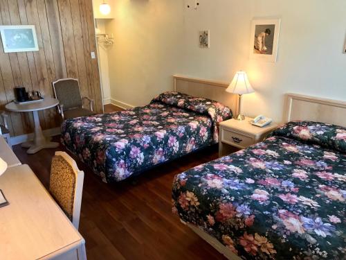 a hotel room with two beds and a table at Lake City Motel in Halifax