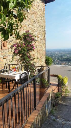 a table and chairs on a balcony of a building at Affittacamere Adri in Uzzano