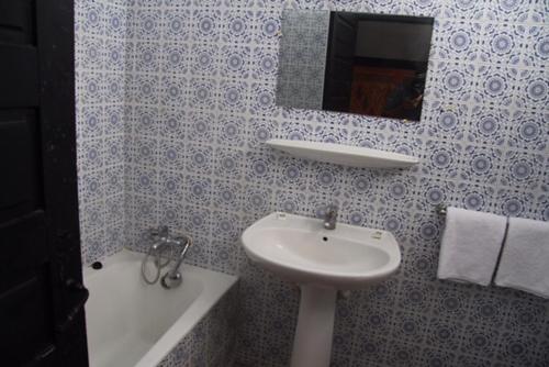 La salle de bains est pourvue d'un lavabo et d'un miroir. dans l'établissement Assam Hotel, à Kenitra
