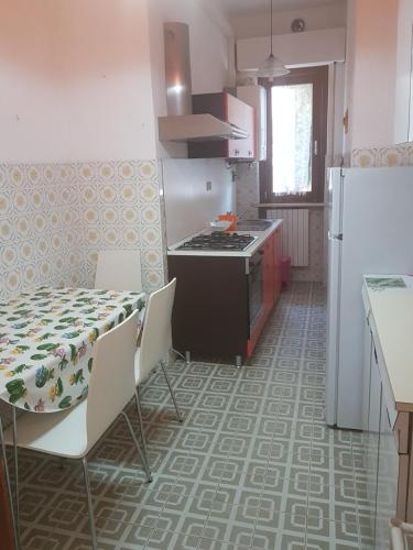 una cucina con tavolo, piano cottura e frigorifero di Casa vacanza Montesilvano a Montesilvano