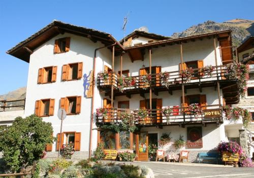 a large white building with balconies and tables at Residence Pavou in Cogne