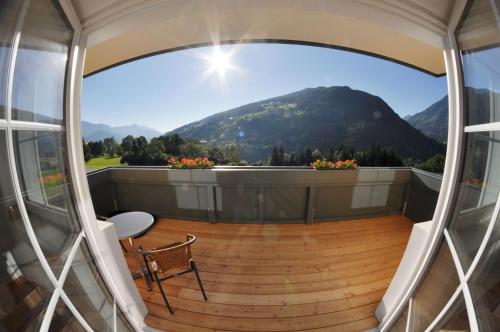 a balcony with a chair and a view of a mountain at Apparthotel Bliem in Schladming