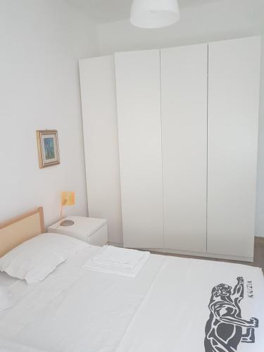 una camera bianca con un letto bianco e un disegno sopra di Casa vacanza Montesilvano a Montesilvano