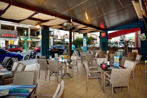 a restaurant with tables and chairs and a street at Akatos Hotel in Agia Marina Nea Kydonias