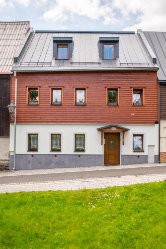 a red and white house with a door at Apartmány Na náměstí in Boží Dar