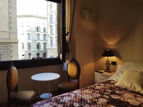 Schlafzimmer mit einem Bett, einem Tisch und einem Fenster in der Unterkunft Lady Luna B&B in Florenz