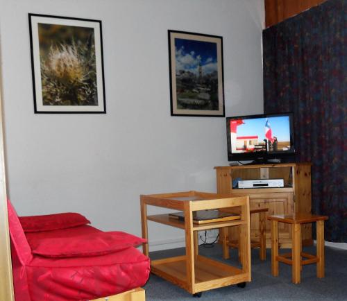 ラ・トゥッスイールにあるLe Mont Charvinのリビングルーム(赤い椅子、テレビ付)
