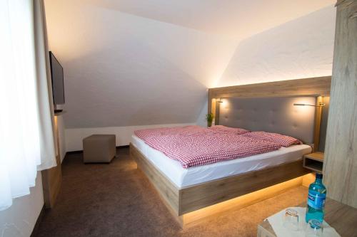 a bedroom with a bed with a red comforter at Pension Klein in Bad Laasphe