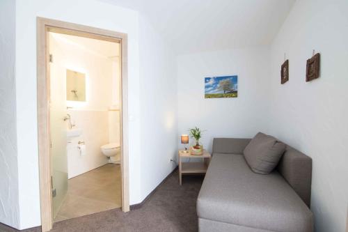 a living room with a couch and a bathroom at Pension Klein in Bad Laasphe