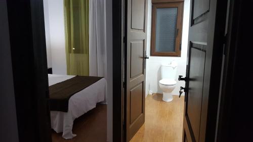a bathroom with a bed and a toilet in a room at Casa Rural CasaBlasa in Santo Domingo de Moya