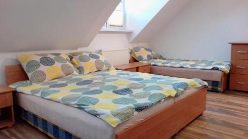 een slaapkamer met 2 aparte bedden op een zolder bij Domus in Ustka